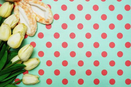 Rabbit ears and tulip flower bouquet on green polka dot backgroundの写真素材