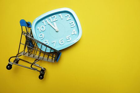 alarm clock and mini trolley cart with space copy on Yellow backgroundの写真素材