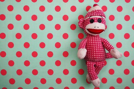 Pink Monkey Doll Top view on Pink and green Polka dot backgroundの写真素材