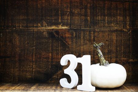 Halloween background concept with number 31 and white pumpkin on wooden backgroundの写真素材