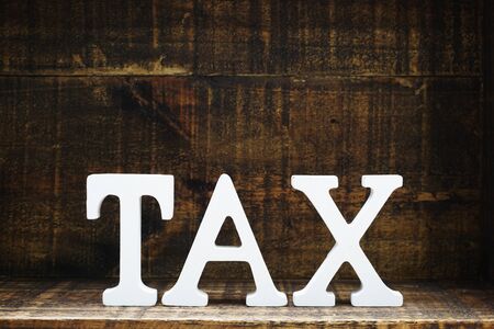 time to pay tax concept tax alphabet letters on wooden backgroundの写真素材