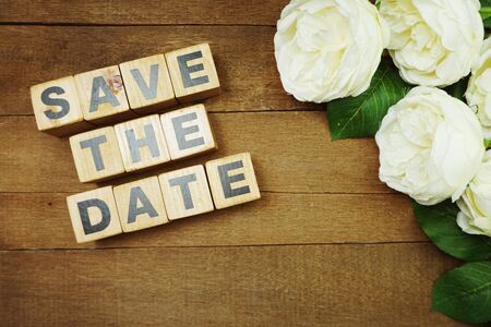Save the Date alphabet letter with white flower bouquet on wooden backgroundの写真素材