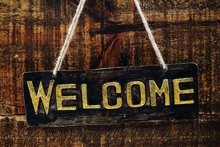 Wooden Welcome sign Hanging on space wooden backgroundの写真素材