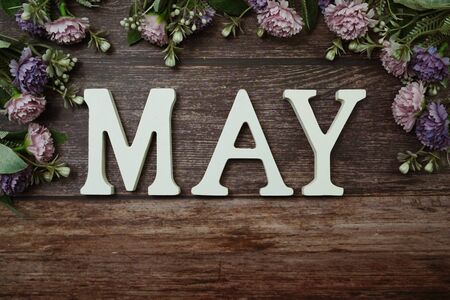 May alphabet letters with flower decoration on wooden backgroundの写真素材