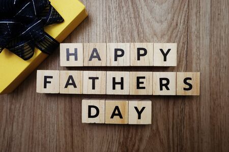Happy Father's Day alphabet letters with gift box on wooden backgroundの写真素材