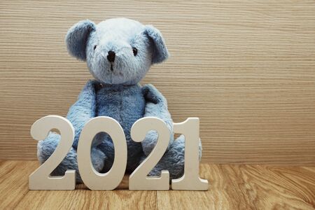 2021 Happy New Year and teddy bear with space copy on wooden backgroundの写真素材
