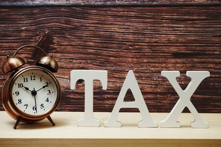 Alarm clock and Tax alphabet letter on wooden backgroundの写真素材