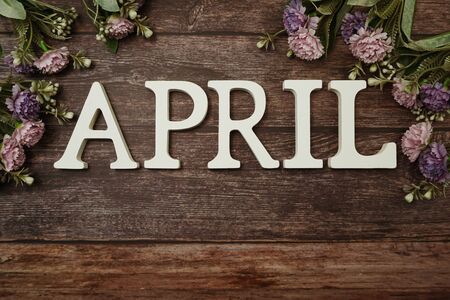 April alphabet letters with flower decoration on wooden backgroundの写真素材