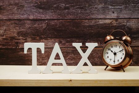 Alarm clock and Tax alphabet letter on wooden backgroundの写真素材