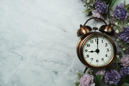 Vintage Alarm Clock And Flower Bouquet with space copy on marble background