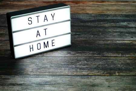 Stay at Home word letter in light box on wooden background