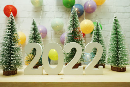Happy New Year 2022 festive background with christmas tree on white brick wall background