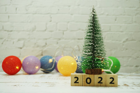 Happy New Year 2022 festive background with christmas tree on white brick wall background