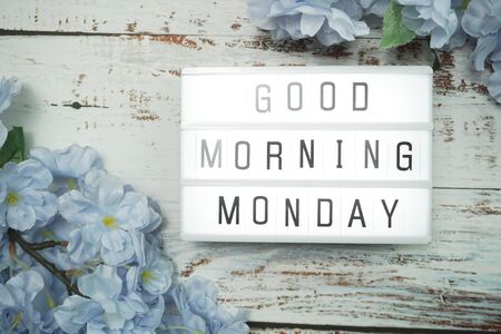 Good Morning Monday word in light box with Flowers Decoration on wooden backgroundの写真素材