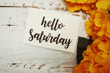Hello Saturday Card with Blooming flower on wooden backgroundの写真素材