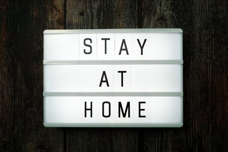 Stay at Home word letter in light box on wooden backgroundの写真素材