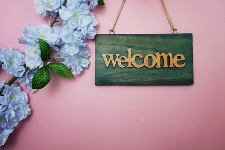 Welcome Sign and Flower Blooming Decoration on pink backgroundの写真素材