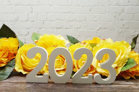 2023 Happy New Year with Roses Flower Decoration with space copy on white brick wallの写真素材