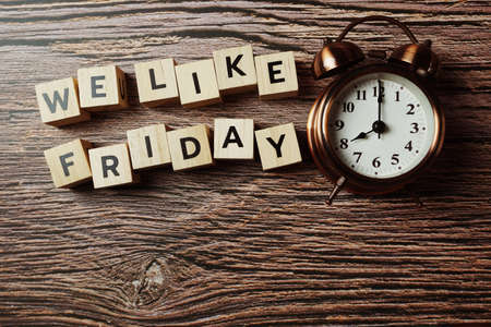 We Like Friday alphabet letter with alarm clock on wooden backgroundの写真素材