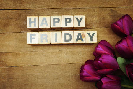Happy Friday alphabet letter with tulip flower on wooden backgroundの写真素材