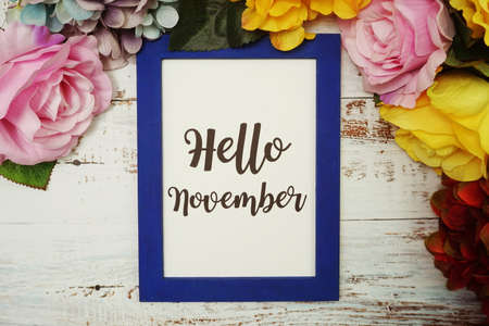 Hello November Card with colorful flowers border frame on wooden backgroundの写真素材