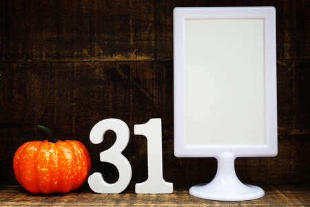 Blank Display frame stand with orange pumpkin on wooden backgroundの写真素材