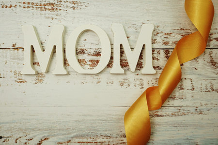 Mother's day background with Mom alphabet letters on wooden background