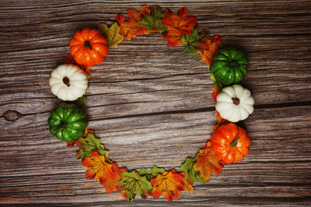 Flat lay colorful autumn Maple leaves border on wooden background
