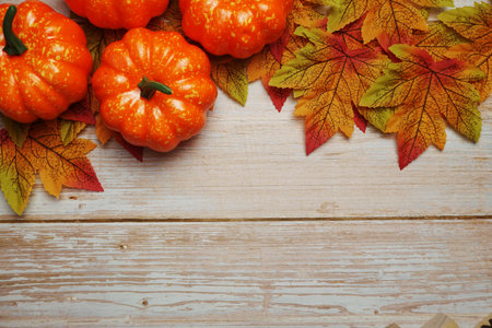 Pumpkin and Autumn leaves with space copy on wooden background