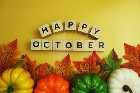 Happy October alphabet letter with maple leaves frame on wooden backgroundの写真素材