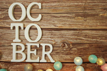 October alphabet letter with LED cotton balls on wooden backgroundの写真素材