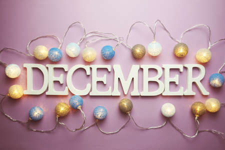 December alphabet letter with cotton ball LED decoration on purple backgroundの写真素材