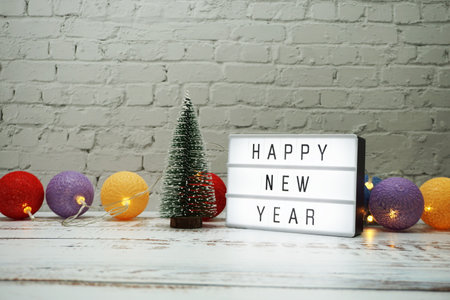 Happy New Year word in light box with Christmas tree and LED cotton ball decorativeの写真素材