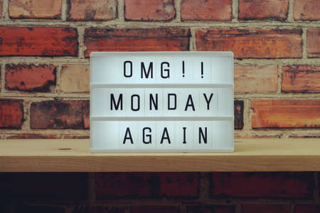 Monday Again word in light box on brick wall and wooden shelves backgroundの写真素材