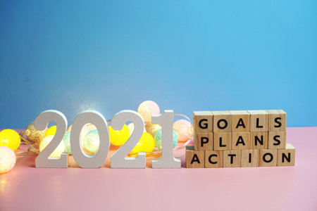 2021 new year goals, plan, action alphabet letters on blue and pink background