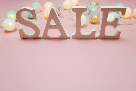 Sale alphabet letter with cotton balls decoration on pink background