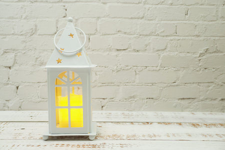 White Lantern decorative with candles with space copy on wooden backgroundの写真素材