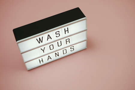 Flat lay Wash Your Hands word in light box with space coy on pink backgroundの写真素材