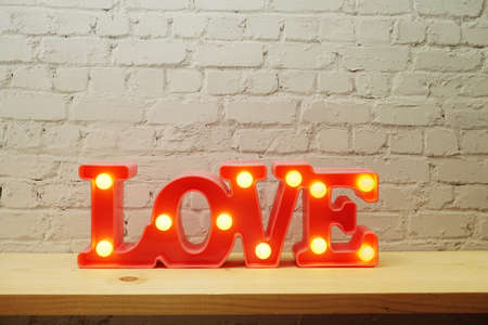 Pink Love LED Decorative on white brick wall backgroundの写真素材