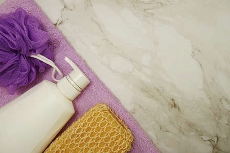Shower accessories bath items shower bottle, sponge and fibre scrub on marble backgroundの写真素材