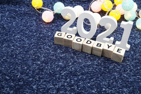 Goodbye 2021 alphabet letter decorate with LED cotton ball on blue knitted fabric background