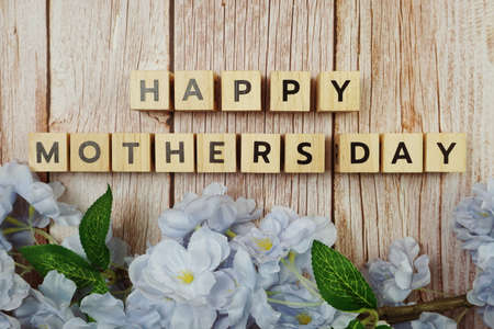 Happy Mothers day alphabet letter with flower decoration on wooden backgroundの写真素材