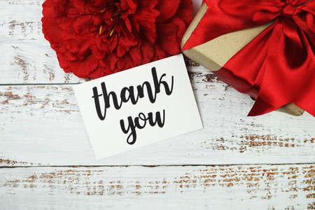 Thank you card with gift box present and flower decoration on wooden backgroundの写真素材