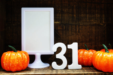 Blank Display frame stand with number 31 and orange pumpkin on wooden background