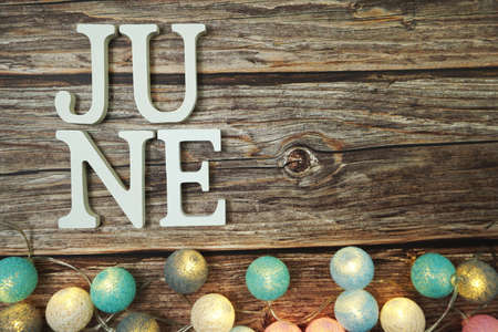 June alphabet letter with LED Cotton ball Decoration on wooden backgroundの写真素材