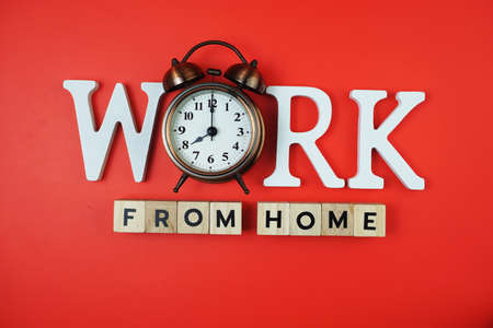 Work from Home alphabet letters with alarm clock on red backgroundの写真素材