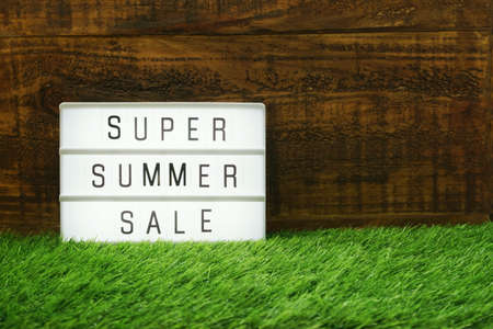 Summer Sale text in light box on wooden backgroundの写真素材