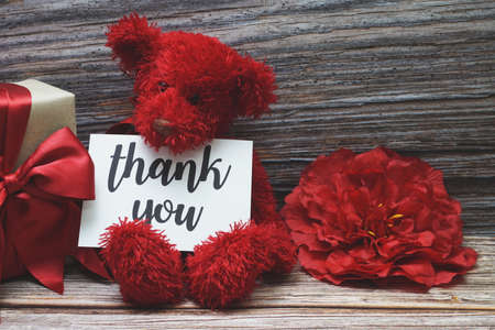 Thank you card with gift box present and flower decoration on wooden backgroundの写真素材