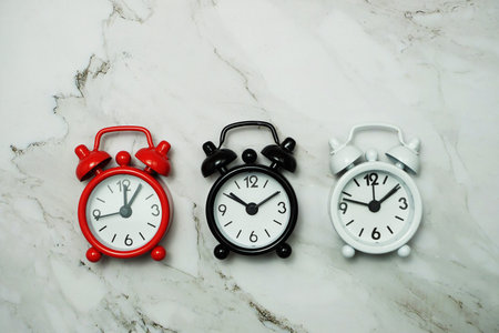 Top view of alarm clocks with different time Flat lay composition on marble background