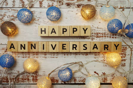 Happy Anniversary alphabet letter with LED cotton balls on wooden backgroundの写真素材